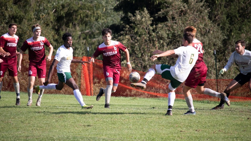 soccer player shooting towards a goal