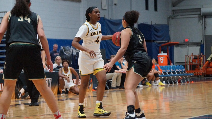 Camryn McDonald #4 dribbles the ball with a defender on her as she looks up to pass the ball.