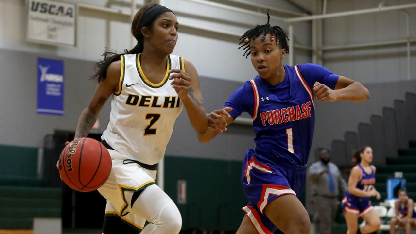 Kiera Holland #2 pushes the ball up court with a defender alongside her.