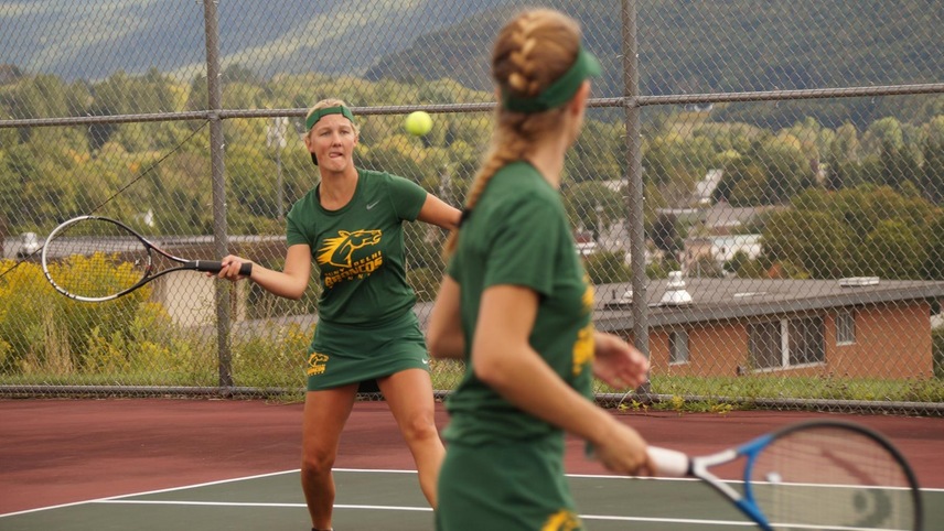 Madison Saleman about to return a ball with partner Susan Hoskins in front of her.